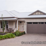 A Better Driveway Modern single-story house with a gray roof, double garage, and landscaped front yard.