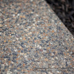A Better Driveway Close-up of exposed aggregate concrete next to dark mulch.