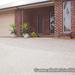 A Better Driveway Front view of a brick house with a smooth concrete driveway and beige garage door.