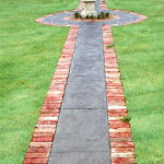 A striking pathway to this homes front door A garden pathway with red brick borders leads to a fountain on a round platform.