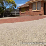 House with a red brick and exposed aggregate driveway.